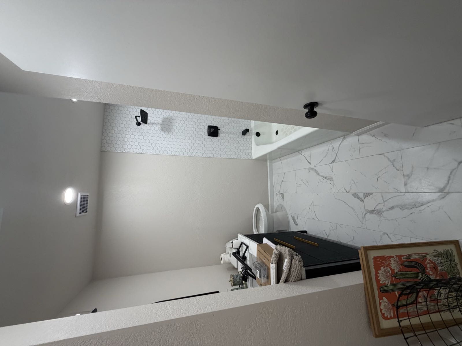 Bright modern bathroom after remodel with hexagon tile shower and matte black fixtures