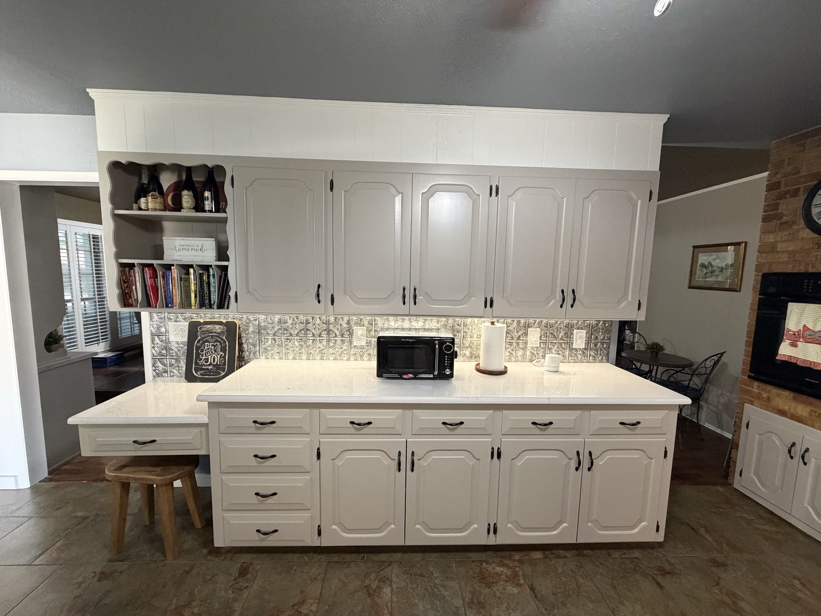 Refreshed kitchen and living space with repainted cabinetry and quartz counters