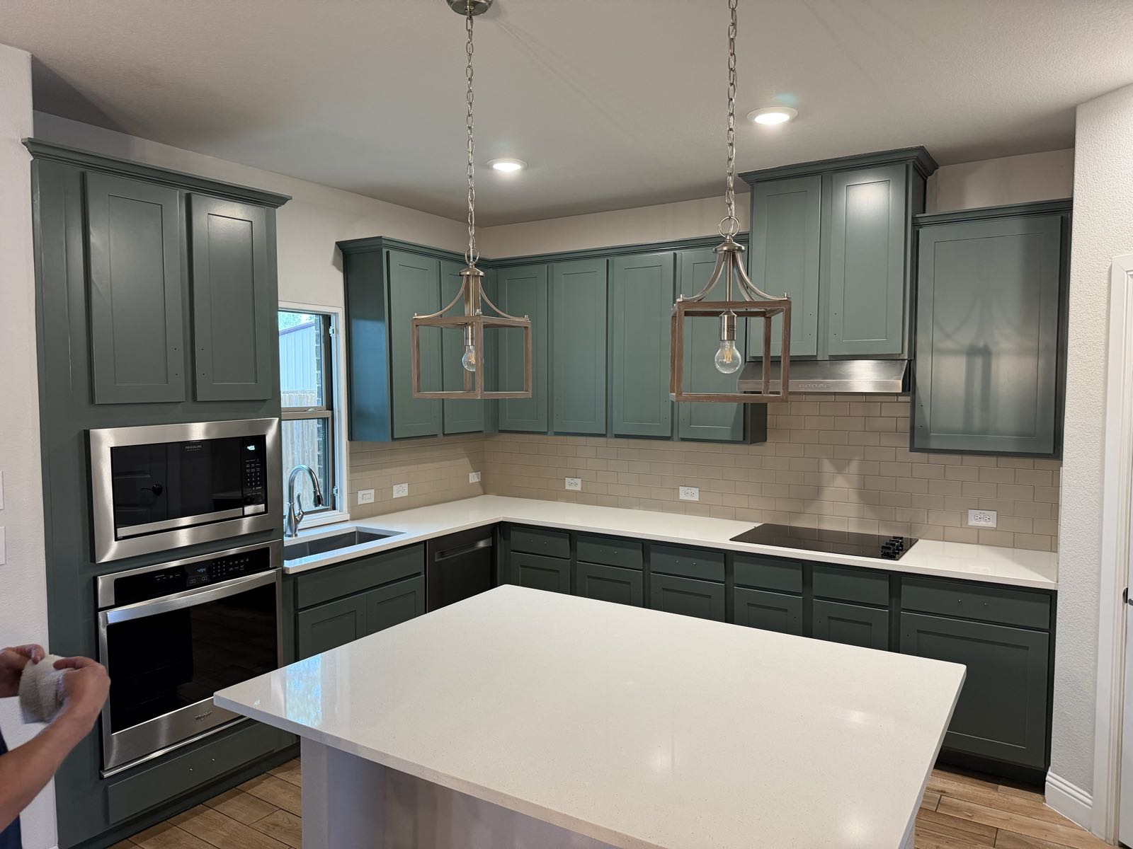 Custom kitchen with sage green cabinetry and quartz island